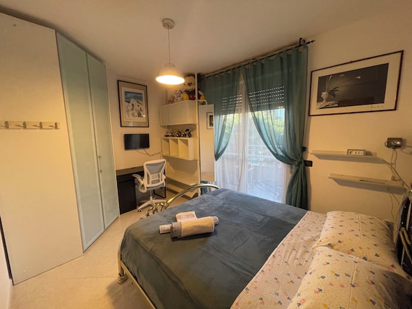 A bedroom with a bed, a desk, a chair, a TV, and a window with curtains. - B&B Imagine (Bari)