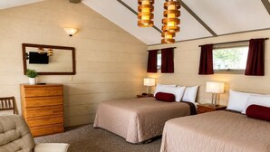 Ein Zimmer mit zwei Betten, einem Holzschrank, einem Stuhl und einem Spiegel.