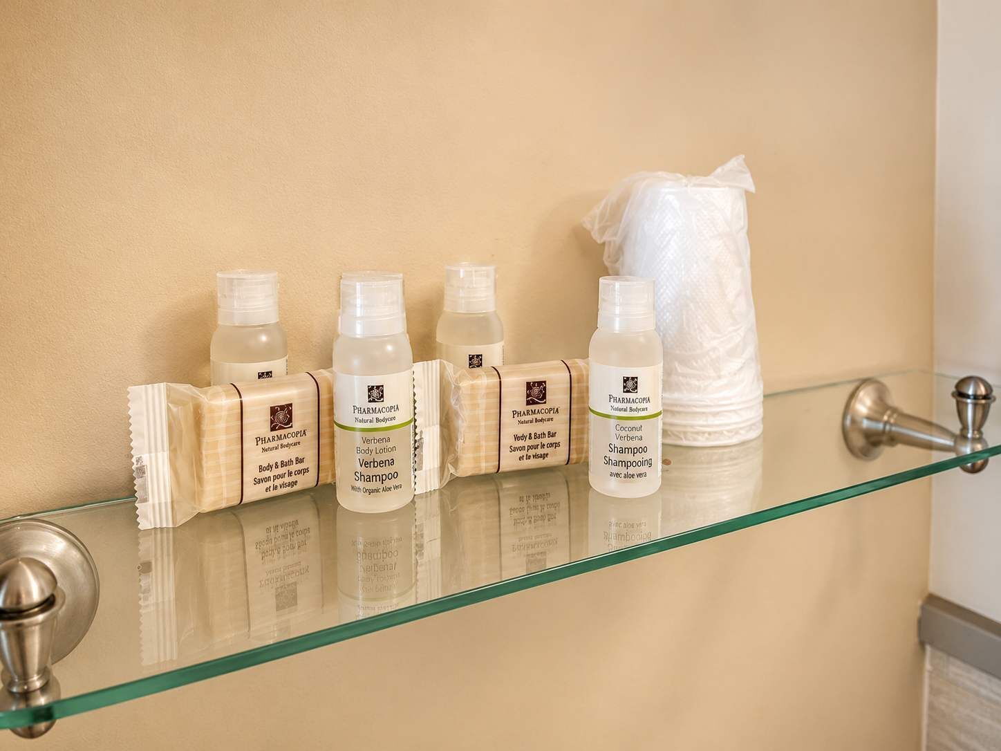 A bathroom shelf with toiletries including body lotion, shampoo, and body bar.