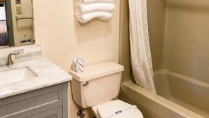 A bathroom with a toilet, sink, and shower. - Pet Friendly Room 23-2 Queen Suite-Woodland Motor Lodge (Grayling)