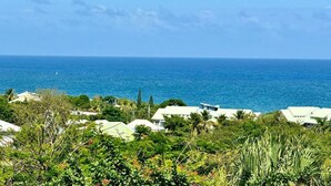 A coastal view with houses and vegetation. - Brand-new studio apartment, ocean view, pool, near beaches (Le Gosier)