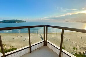 Uma varanda com vista para a praia e o mar.