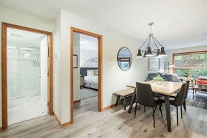 Ein modernes Interieur mit Essbereich, Wohnzimmer und einer Glasdusche.