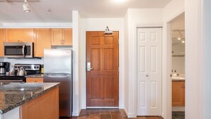 A kitchen with a microwave, stove, refrigerator, and granite countertop. - SKI-IN/SKI-OUT 1BDR Condo with Pool & Hot Tub | Spectacular location! (Whistler)