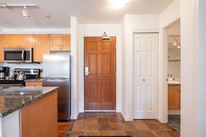A kitchen with a microwave, stove, refrigerator, and granite countertop. - SKI-IN/SKI-OUT 1BDR Condo with Pool & Hot Tub | Spectacular location! (Whistler)