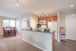 Une cuisine moderne avec des meubles en bois, un îlot central et un coin repas avec des chaises.