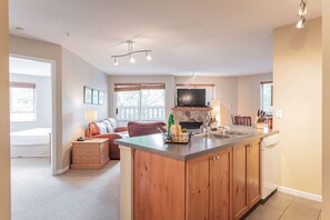 Et moderne køkken med en central ø, integrerede hårde hvidevarer og et spiseområde med udsigt.