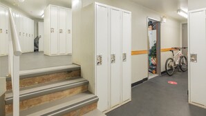 Um corredor com armários, uma bicicleta e uma escada.