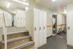 Ein Flur mit Schließfächern, einem Fahrrad und einer Treppe.