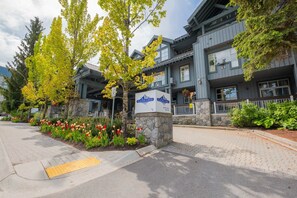 Ein Hotel mit Steinfassade, mehreren Balkonen und einem Schild, das es als Glacier Lodge kennzeichnet.