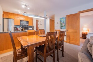 Een compacte leefruimte met eethoek, kitchenette en slaapkamer.