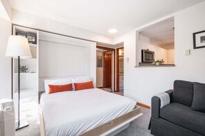 Une chambre d’hôtel avec un lit, un canapé, un bureau et un miroir.