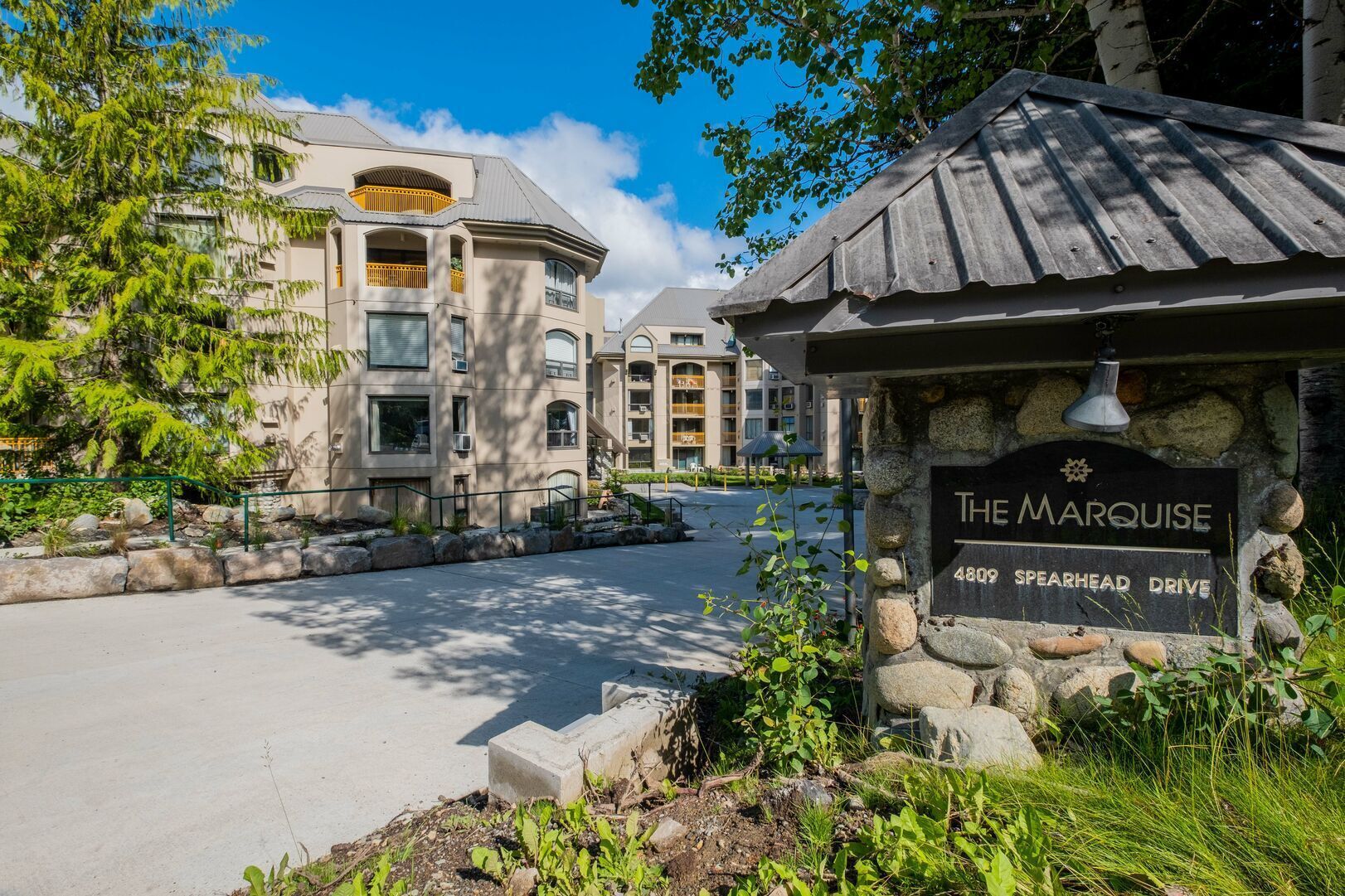 A stone sign with "The Marquise" and "4809 Spearhead Drive" indicating a hotel.