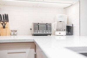 A kitchen with a toaster, coffee maker, and a trash bin. - Pool & hot tub | Free parking | Excellent location (Whistler)