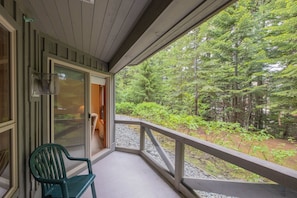 A wooden porch with a view of a forest. - Ski-in/out apartment | Shared Hot Tub, Pool & Gym | Superb location (Whistler)