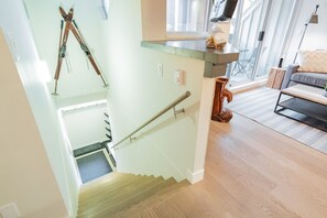 A staircase with a handrail, a wooden floor, and a glass railing.