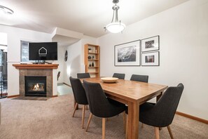 A modern dining room with a fireplace, a television, and a bookshelf. - Central location | Pets | BBQ | Free parking (Whistler)