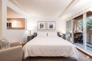 A hotel room with a bed, a sofa, a desk with a lamp, and a large window. - Central location | Pets | BBQ | Free parking (Whistler)