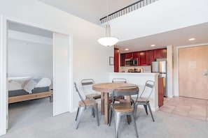 A modern apartment with a dining area, kitchenette, and a bedroom. - Village location| Pool & hot tub | Free parking (Whistler)