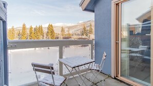 En balkong med utsikt över snötäckta träd och berg.