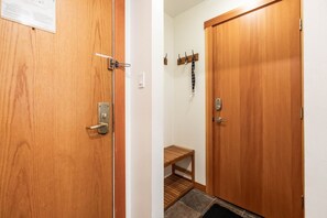Una puerta de madera con un cerrojo y un pequeño estante con una toalla.