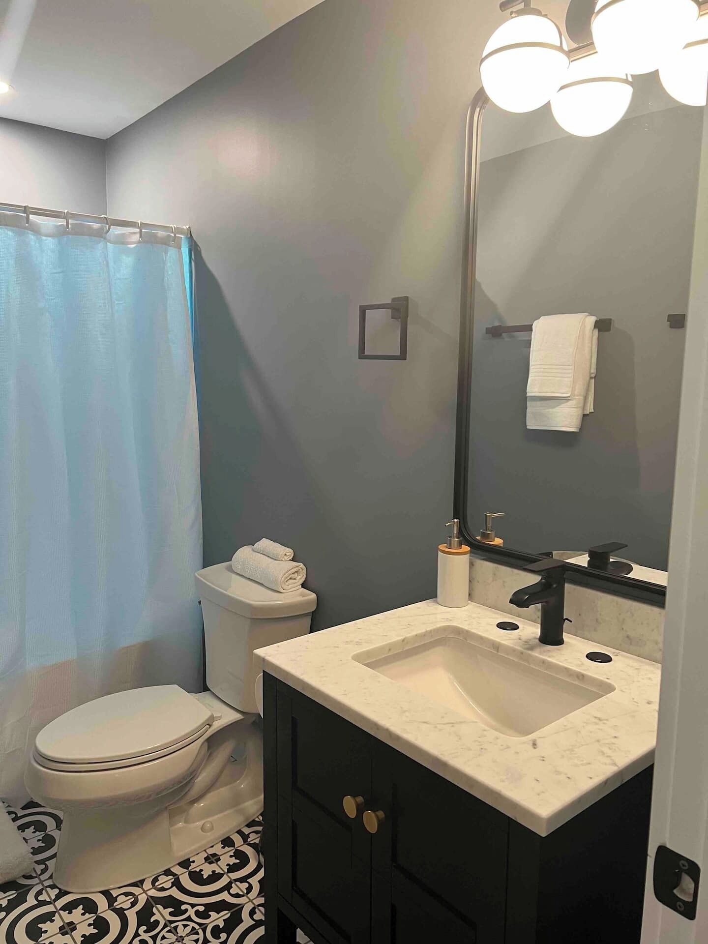 Ein Badezimmer mit Toilette, Waschbecken, Spiegel und Handtuchhalter.