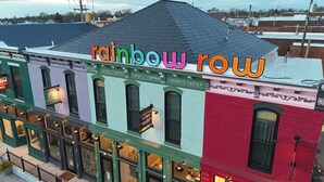 A multi-story building with a colorful facade and a sign reading 'rainbow row.' - African Inspired 1BR Flat - Downtown Bellefontaine (Bellefontaine)