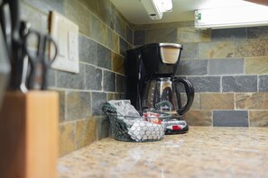 A kitchen with a coffee maker, a basket of coffee pods, and a countertop. - Updated 2BDR | Perfectly located! Close to Gondola (Whistler)