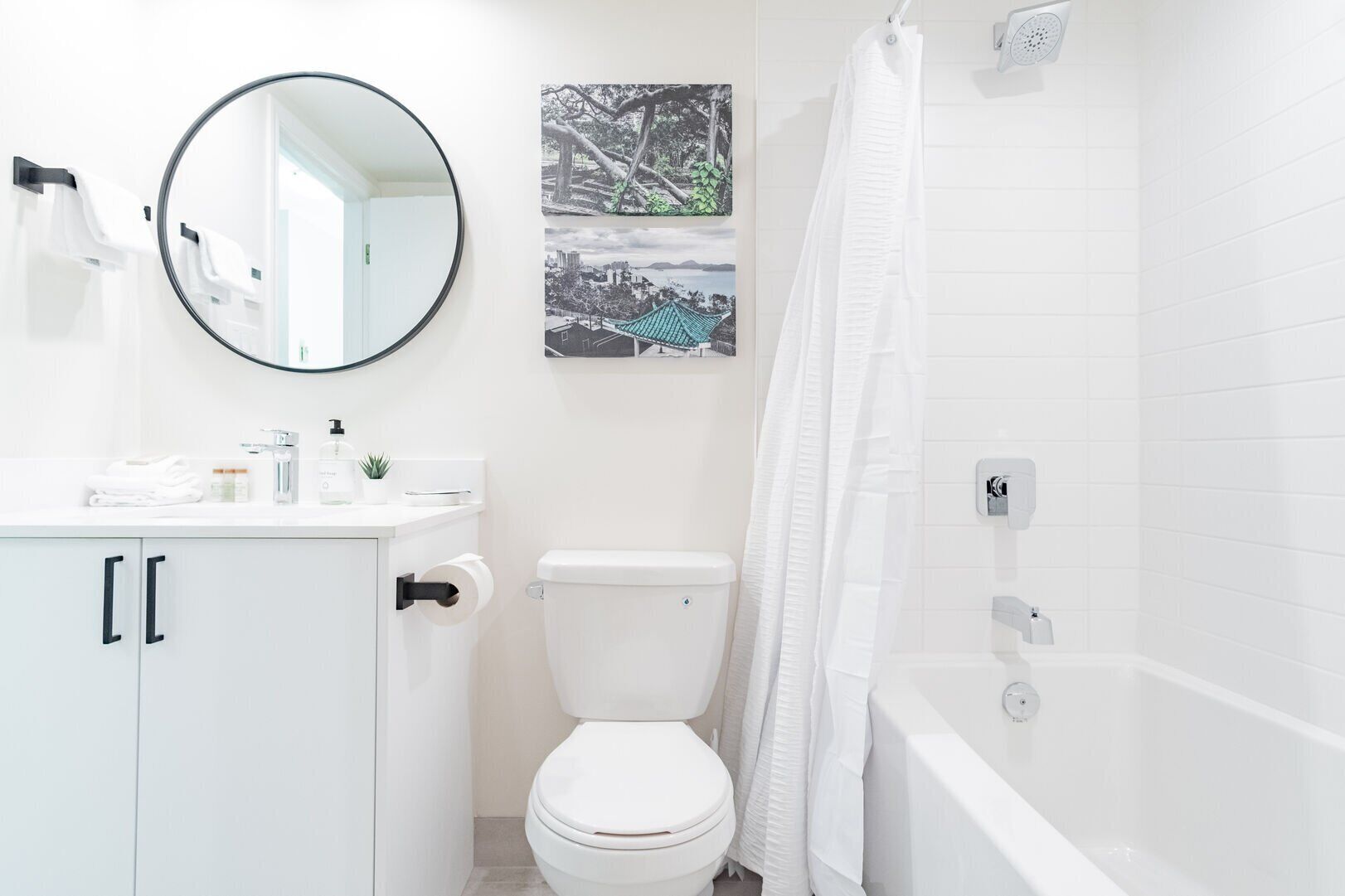 A modern bathroom with a toilet, sink, mirror, and shower.