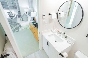 Een moderne slaapkamer met een bed, nachtkastje, lamp en uitzicht.