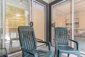 Two green chairs in front of a glass door with a view of a building. - Stylish | Steps to Blackcomb | Free Parking (Whistler)