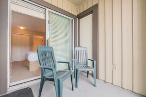 A room with a bed, a window with blinds, and two chairs outside. - Budget friendly Comfortable 1BDR | Close to Lifts (Whistler)