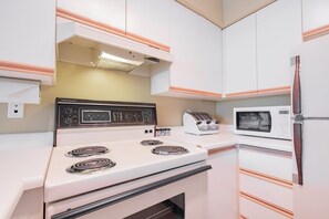 A compact kitchen with a white stove, a toaster, and a microwave. - Budget friendly Comfortable 1BDR | Close to Lifts (Whistler)