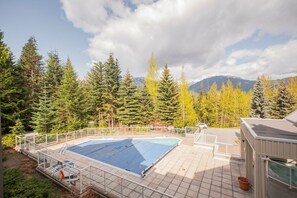 A swimming pool with a view of a forest and mountains in the background. - Budget friendly Comfortable 1BDR | Close to Lifts (Whistler)