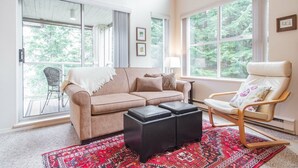 A living room with a sofa, a chair, a coffee table, and a patterned rug. - Modern 2BDR + Loft | Close to Ski Lifts and Shops (Whistler)