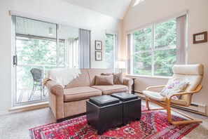 A living room with a sofa, a chair, a coffee table, and a patterned rug. - Modern 2BDR + Loft | Close to Ski Lifts and Shops (Whistler)