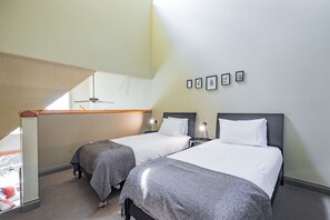 A hotel room with two beds, a ceiling fan, a small table with a lamp, and framed pictures on the wall. - Complex hot tub | Close to Lifts | Free Parking (Whistler)