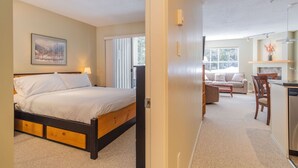 A bedroom with a bed, bedside table, and a window. - Short walk to Blackcomb | Free parking | Hot tub (Whistler)