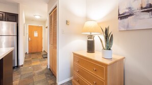 A hallway with a wooden cabinet, a lamp, and a potted plant. - Comfortable 2 Bdrm | Hot tub in complex | 5 min to Blackcomb (Whistler)