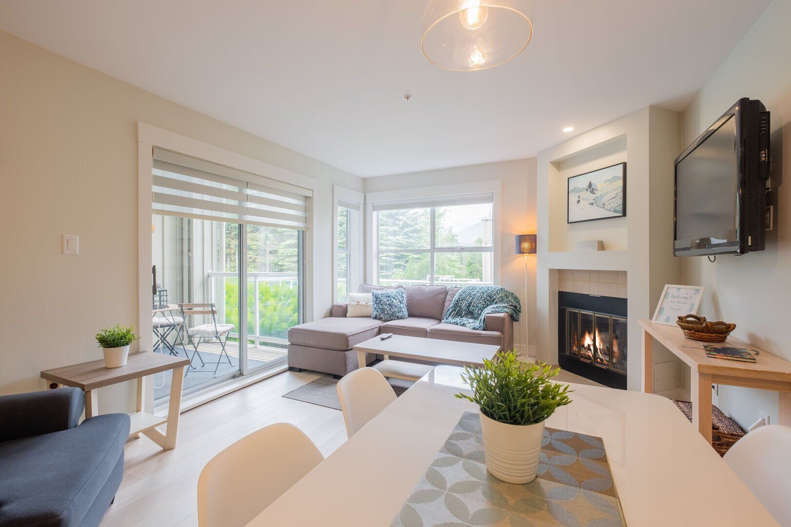 A modern living room with a fireplace, a television, and a dining area.