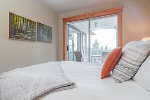 Une chambre à coucher avec un lit, une fenêtre et deux tableaux accrochés au mur.