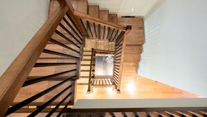 Een houten trap met een modern ontwerp, die naar een verdieping leidt.