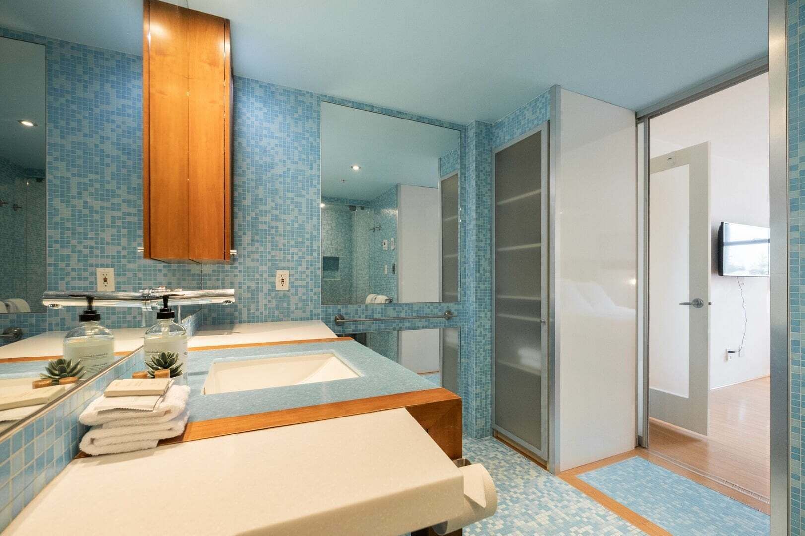 Un baño moderno con dos lavamanos, una ducha y un espejo grande.