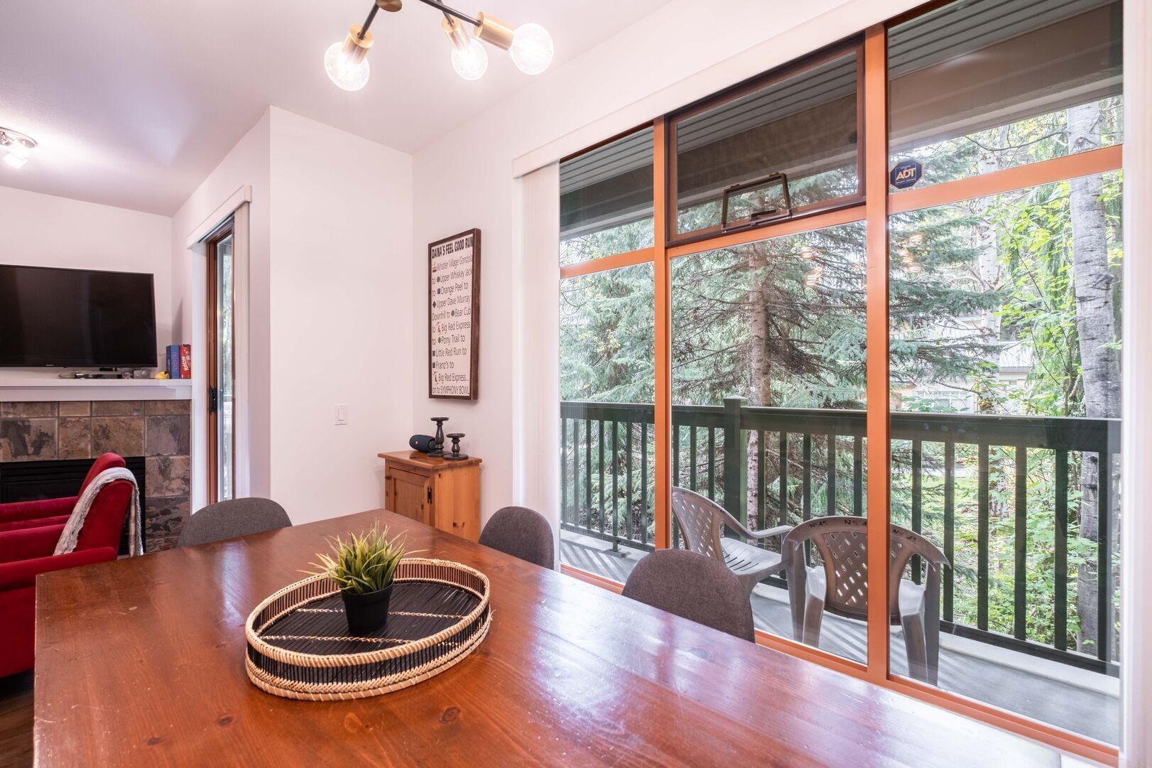 Un comedor con mesa de madera, sillas, televisor y chimenea.