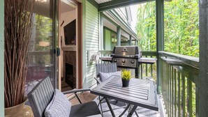 A covered outdoor area with a grill, seating, and a view of greenery. - Perfect location | Free Parking | Pool & Hot Tub (Whistler)