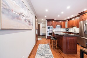 Une cuisine moderne avec des meubles en bois, des appareils en acier inoxydable et un grand îlot central.