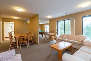 Un vaste espace de vie comprenant un canapé, une table basse et une table à manger avec des chaises.