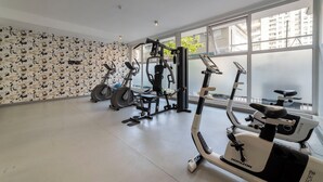 A gym with cardio machines, weight equipment, and large windows. - San Isidro Ideal for Families 4 (Santiago)