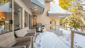 A modern house with a covered porch, outdoor seating, and a grill. - Gorgeous townhouse | Private hot tub | BBQ (Whistler)