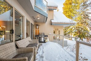 A modern house with a covered porch, outdoor seating, and a grill. - Gorgeous townhouse | Private hot tub | BBQ (Whistler)